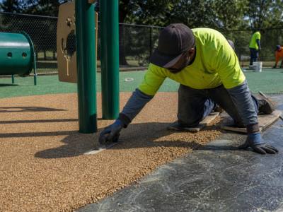 Crew pouring rubber surfacing at a dog park