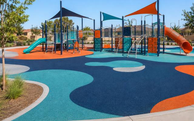 Playground climbing structure on blue, orange and teal rubber safety surfacing